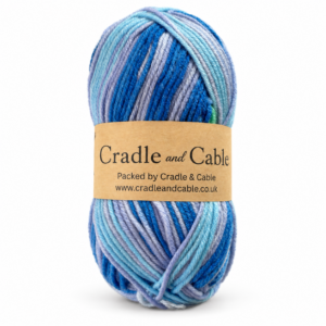 Seaglass Cove Aran Yarn in blue, aqua and lilac shades with a Cradle and Cable kraft label.