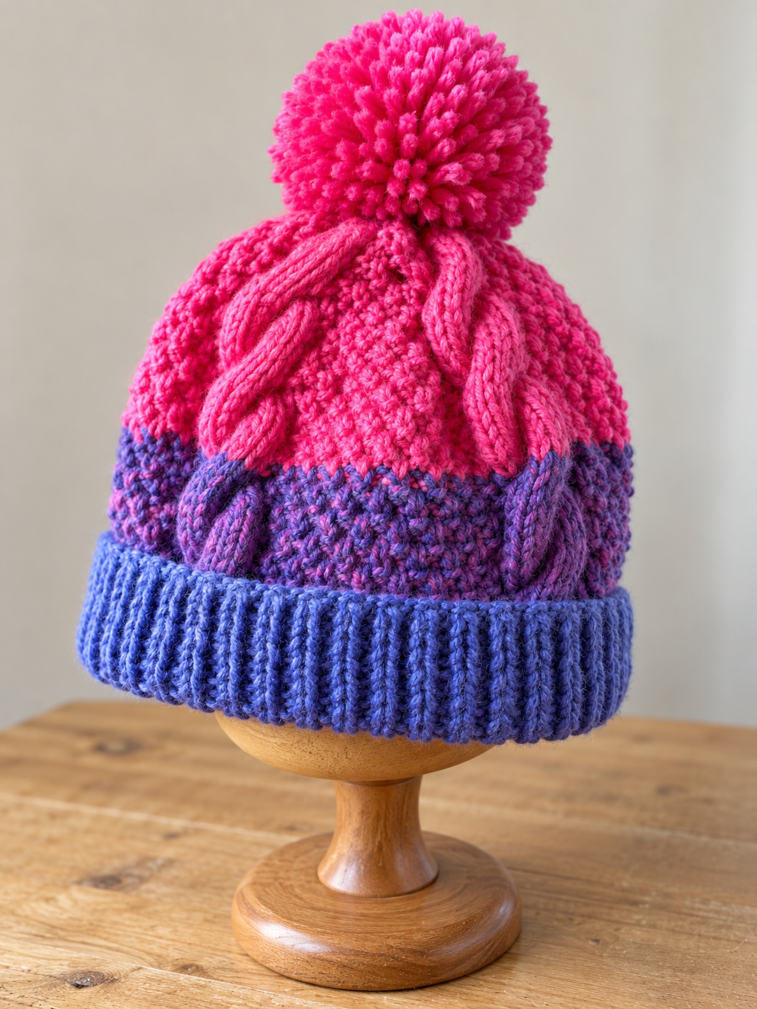 Berry Burst hand knitted cable beanie in pink purple and blue with pom pom